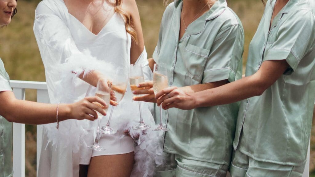 Beautiful bride does cheers with her bridesmaids in matching pyjamas while getting ready for her Gippsland Wedding
